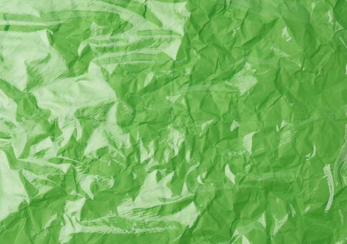 texture of a transparent stretching plastic film for packaging products on a green background, full frame, close up