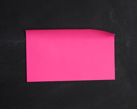 blank  paper pink sticker glued on black chalkboard, place for inscription