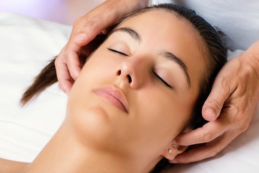 Close up portrait of woman at cosmetic beauty session.Therapist massaging side of female ears.