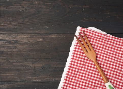 wooden fork lie on a brown wooden background from boards, top view, copy space