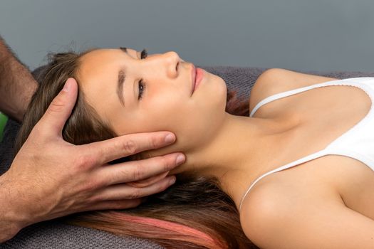 Close up of therapist doing healing physical cranial therapy on child.