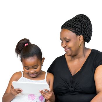 Close up portrait of little african girl with mother isolated on white background.Mother and daughter looking together at digital tablet.