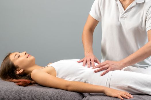 Close up of physiotherapist doing abdomen massage on child.