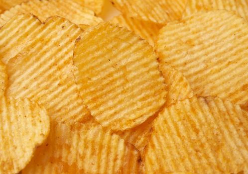 texture of round fried potato corrugated chips, full frame, close up