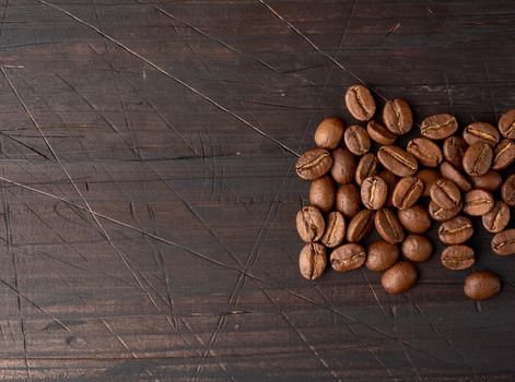 roasted coffee beans arabica on a wooden table, black background, place for an inscription