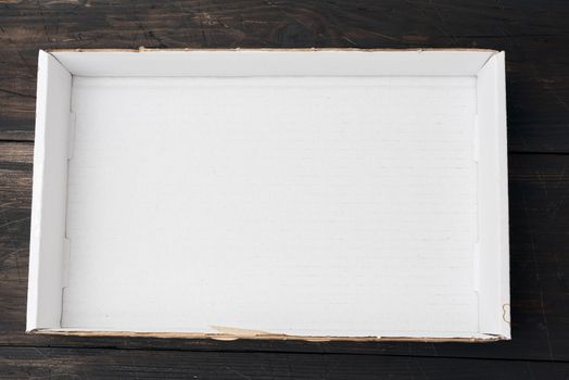 empty white cardboard paper box on wooden background, top view