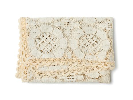 folded beige lace tablecloth and isolated on a white background, top view
