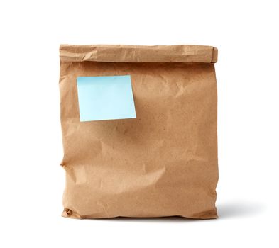 full paper disposable bag of brown kraft paper with a sticky blue blank sticker isolated on white background, concept of rejection of plastic packaging, template for designer