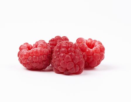 whole ripe red raspberries on a white background, summer berry