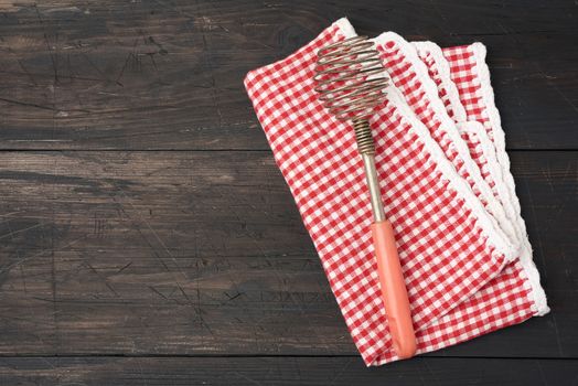 vintage iron whisk for whipping food, wooden background 