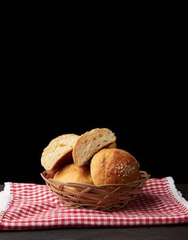 baked round bun with sesame seeds, black background, home baking, copy space