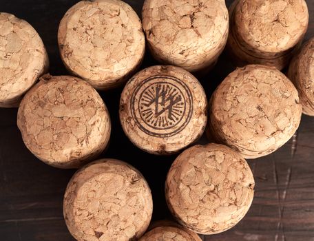 stack of corks for glass wine and champagne bottles on wooden background, copy space, top view