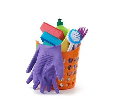 orange basket with washing sponges, rubber protective gloves, brushes and cleaning agent in a green plastic bottle, set isolated on a white background