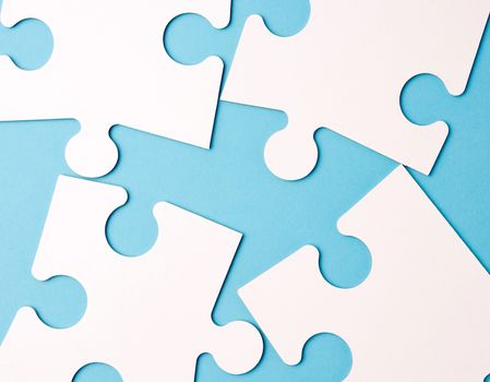 empty white big puzzles on a blue background. Concept in business, close up
