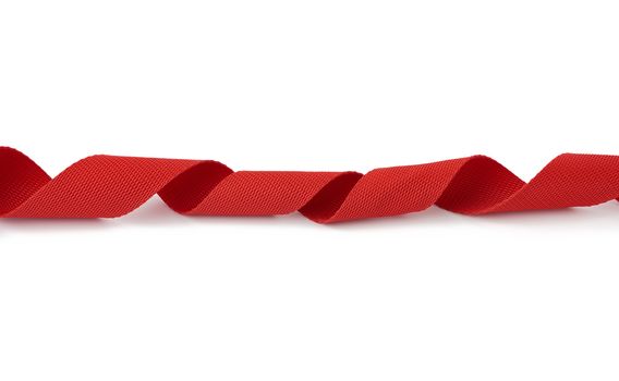 twisted red textile tape for belts and handles of bags isolated on a white background