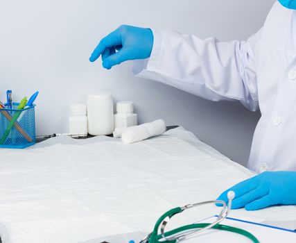 doctor in a white medical coat sits at a table, workplace for receiving patients, white background