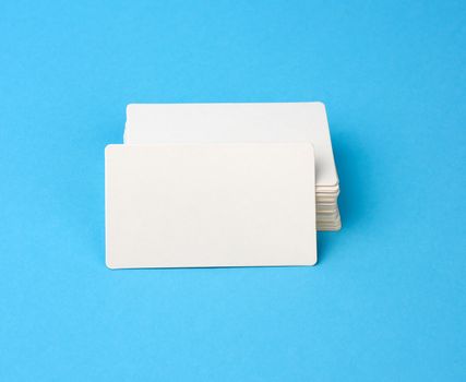 stack of rectangular white blank business cards on a blue background, backdrop for the designer