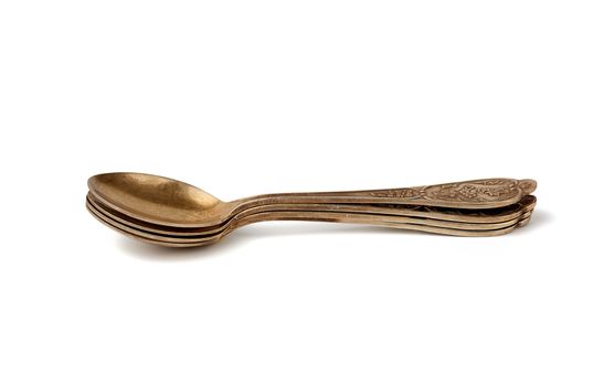 golden metal vintage small coffee spoon for pouring sugar isolated on a white background, stack