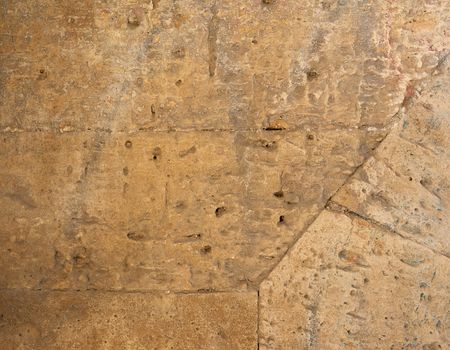 wall of yellow rectangular stones with cement, fragment of ancient architecture, full frame, close up