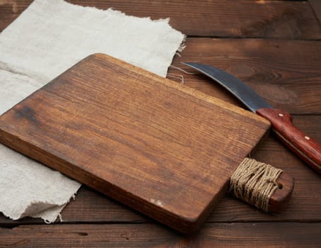very old empty wooden rectangular cutting board and knife, top view,  wooden background 