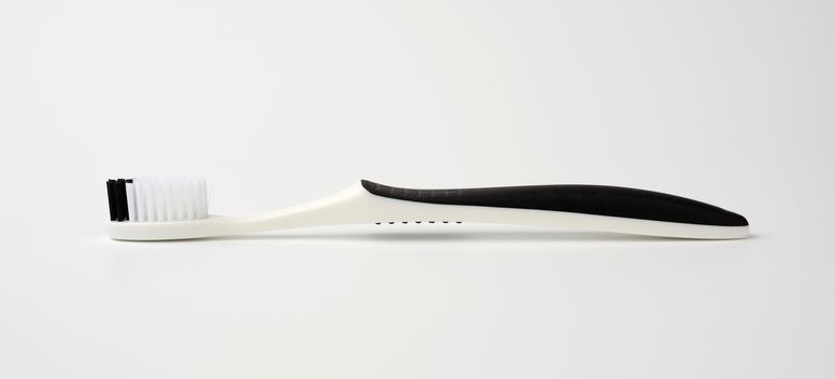 black plastic toothbrush for cleaning the oral cavity, object on a white background