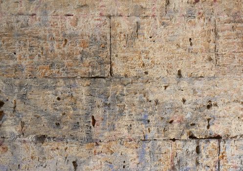 wall of yellow rectangular stones with cement, fragment of ancient architecture, full frame, close up