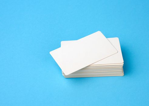 stack of rectangular white blank business cards on a blue background, backdrop for the designer