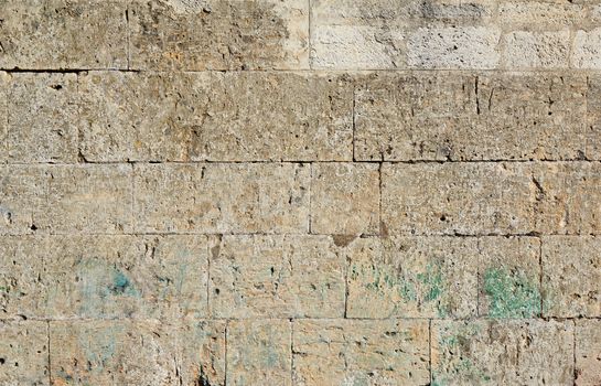 wall of yellow rectangular stones with cement, fragment of ancient architecture, full frame