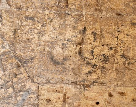 wall of yellow rectangular stones with cement, fragment of ancient architecture, full frame, close up