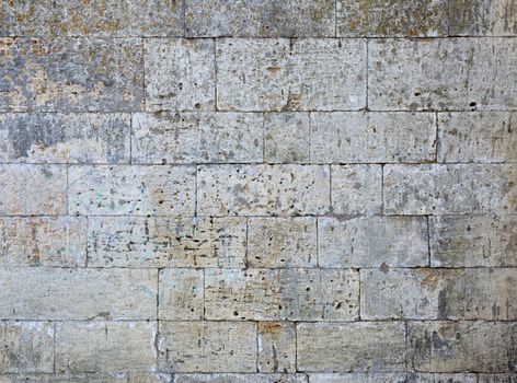 wall of yellow rectangular stones with cement, fragment of ancient architecture, full frame