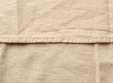 beige cotton fabric texture with stitching, vintage kitchen napkin, full frame, close up