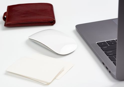 open gray laptop stands on a white table, next to a wireless mouse, freelancer workplace, businessman, close up
