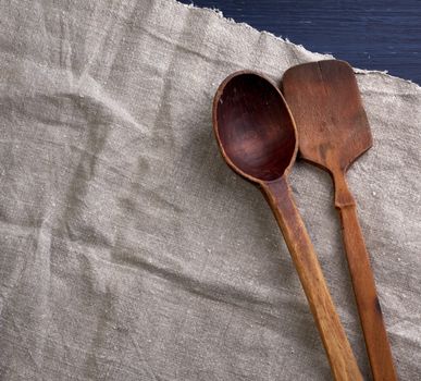 old empty brown wooden spoon on a gray surface, top view