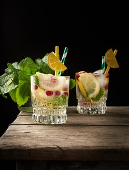 transparent glass with lemonade and pieces of ice, red berries, a refreshing summer drink 