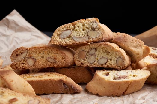 pieces of baked italian christmas biscotti cookies on a brown crumpled paper, close up
