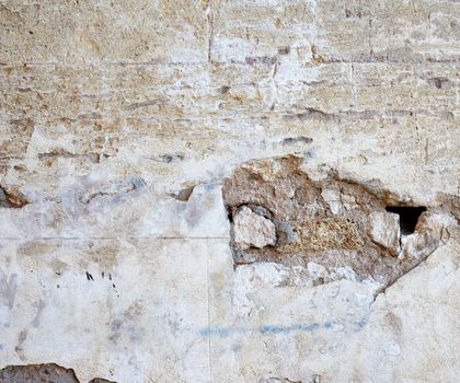 wall of yellow rectangular stones with cement, fragment of ancient architecture, full frame