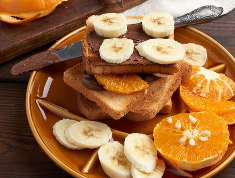 sandwiches with chocolate paste and banana slices on a plate, morning breakfast