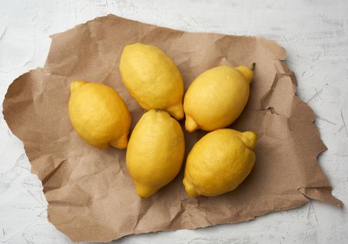 ripe yellow lemons on a gray table, ingredient for lemonade, top view