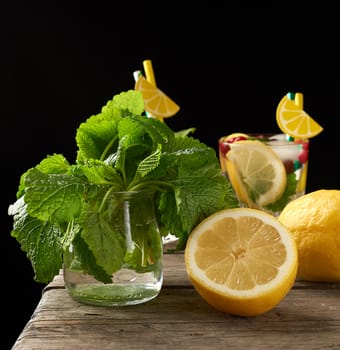 yellow ripe lemon and a bunch of fresh green mint on a wooden board, ingredients for lemonade