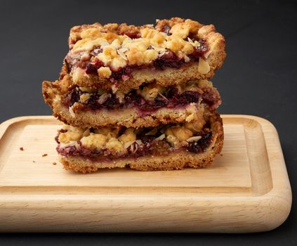 plum pie crumble on a brown wooden cutting board, close up