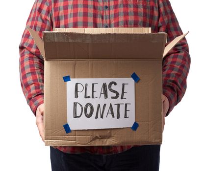 man in a plaid shirt and jeans holds a brown cardboard box with the inscription please donate, concept of a request for help to those in need