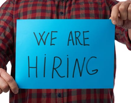 blue piece of paper with the inscription we are hiring, concept of unemployment against the backdrop of the global crisis, fired employee