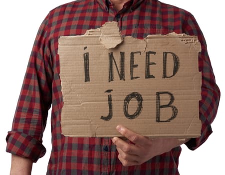 man in a plaid shirt and jeans holds a piece of paper with the inscription i need job, concept of unemployment against the backdrop of the global crisis, fired employee, man is isolated on a white