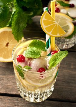 transparent glass with lemonade and pieces of ice, red berries, a refreshing summer drink , top view
