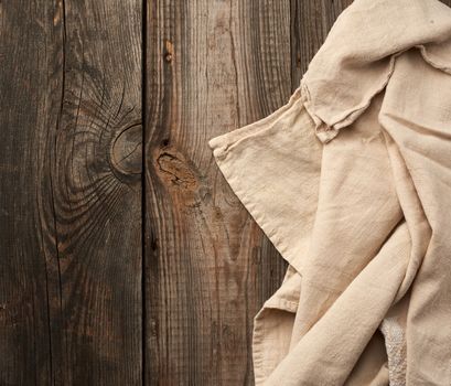 gray kitchen textile towel folded on a gray wooden table from old boards, top view, empty space. Rustic texture. Retro background