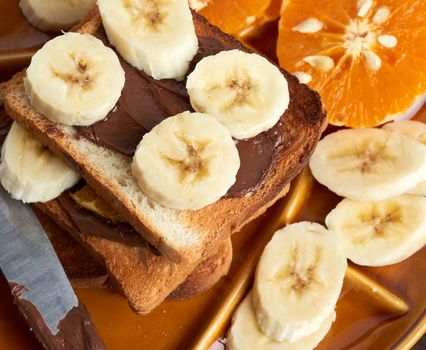 sandwiches with chocolate paste and banana slices on a plate, morning breakfast
