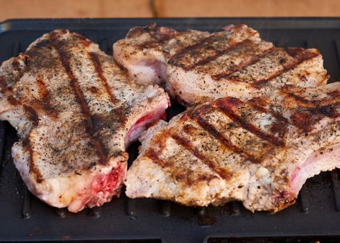 grilled pork tenderloin on the ribs, delicious food, spiced meat, close up