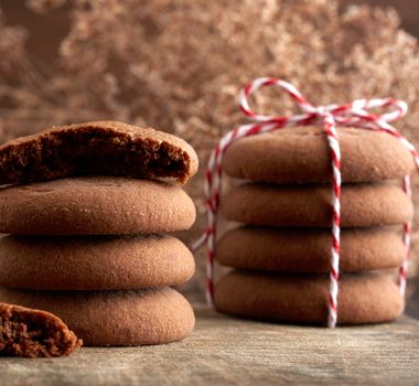 stack of round chocolate chip cookies tied with a rope on a brown board, delicious dessert