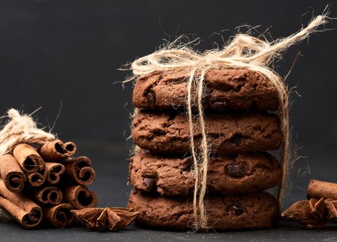 stack of round chocolate chip cookies tied with a rope on a black board, delicious dessert