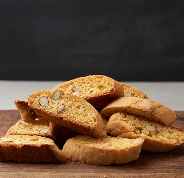 pieces of baked italian christmas biscotti cookies on a brown wooden board, copy space